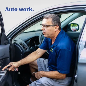 A Locksmith Technician working on a vehicle